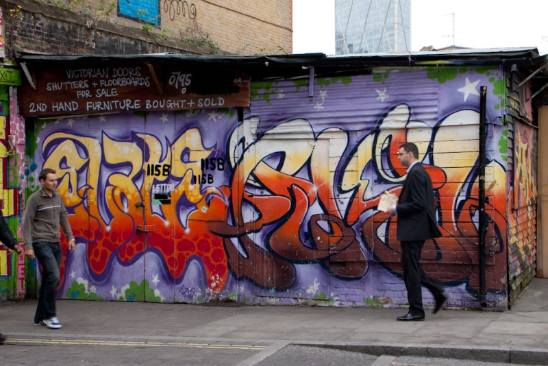 2 men in front of graffiti wall