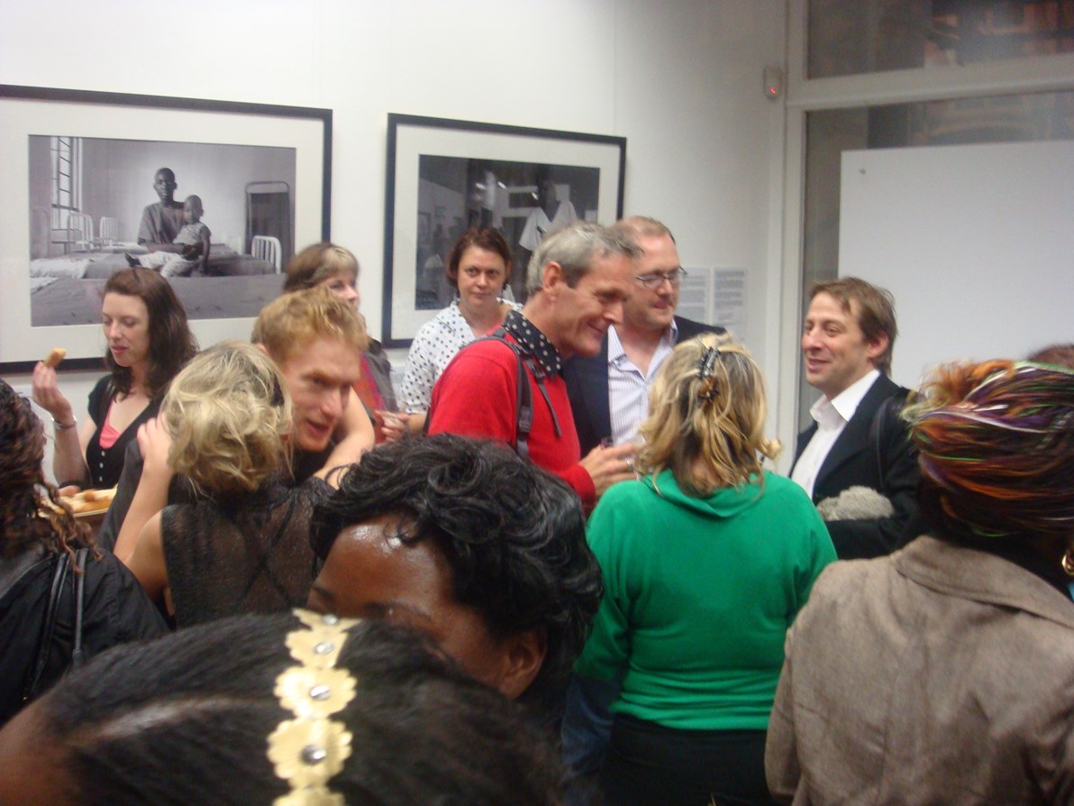 crowd of people talking in an art gallery