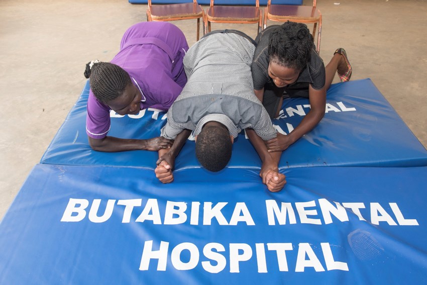 two nurses helping a man with physical therapy