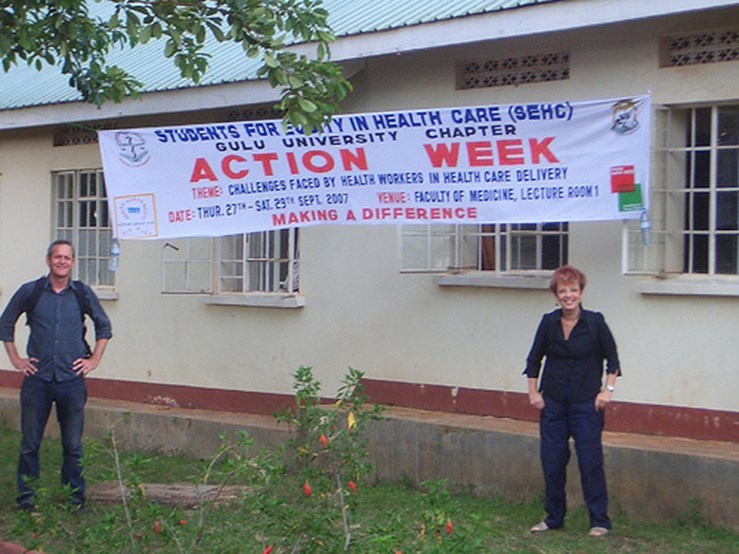 two people standing beneath an "Action Week" banner