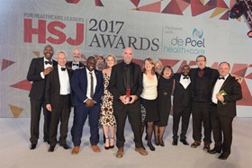 people standing smiling at the camera holding an award