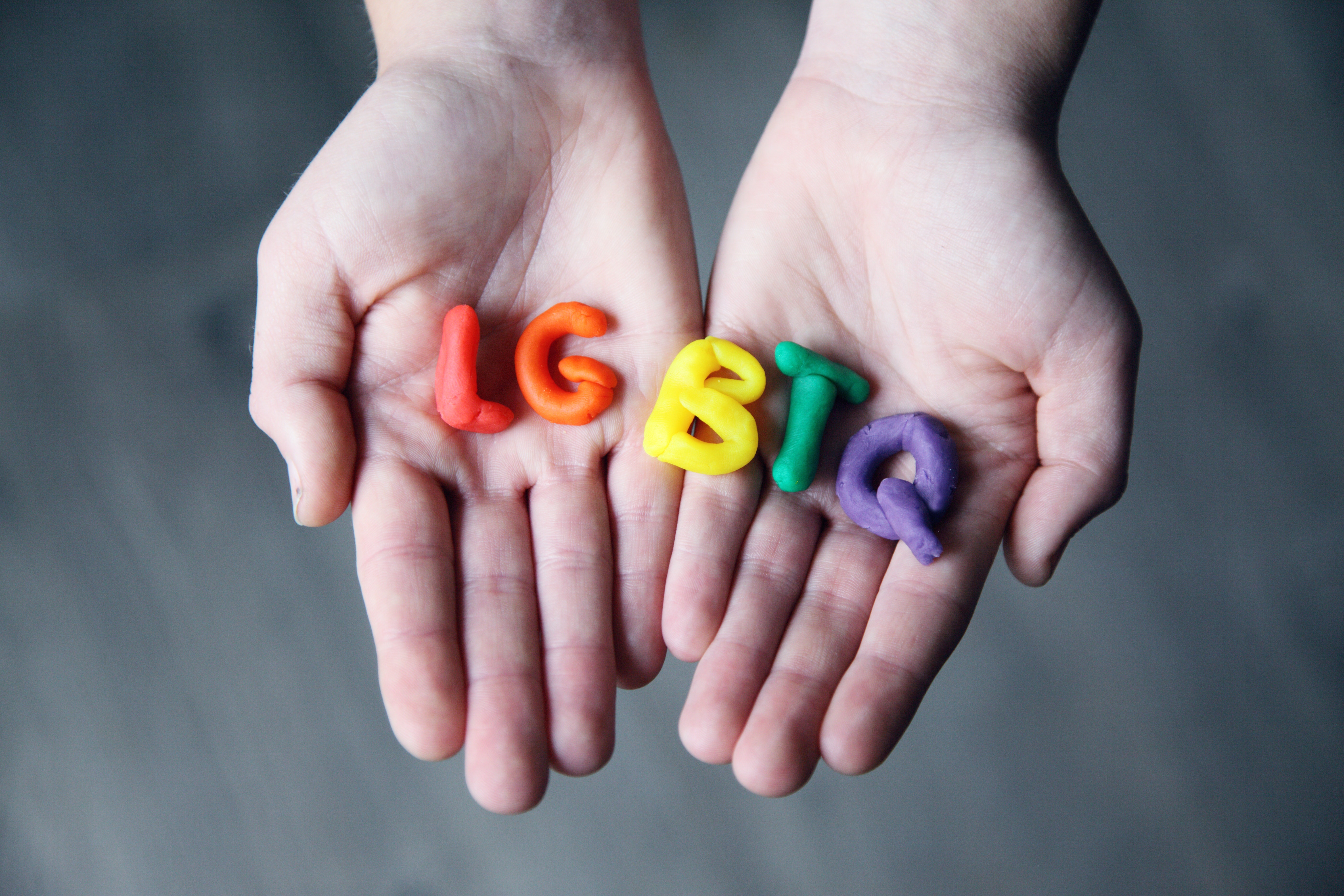 Hands holding LGBTQ+ letters