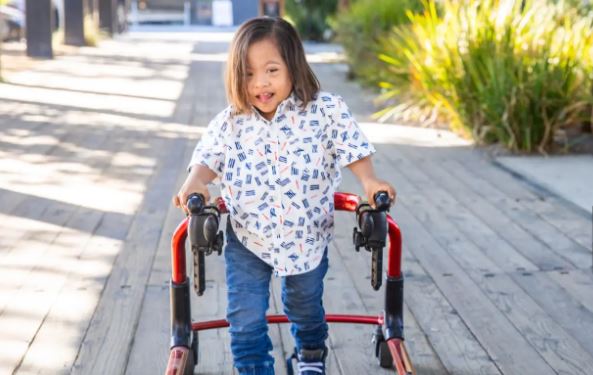 Child walking with a red walker