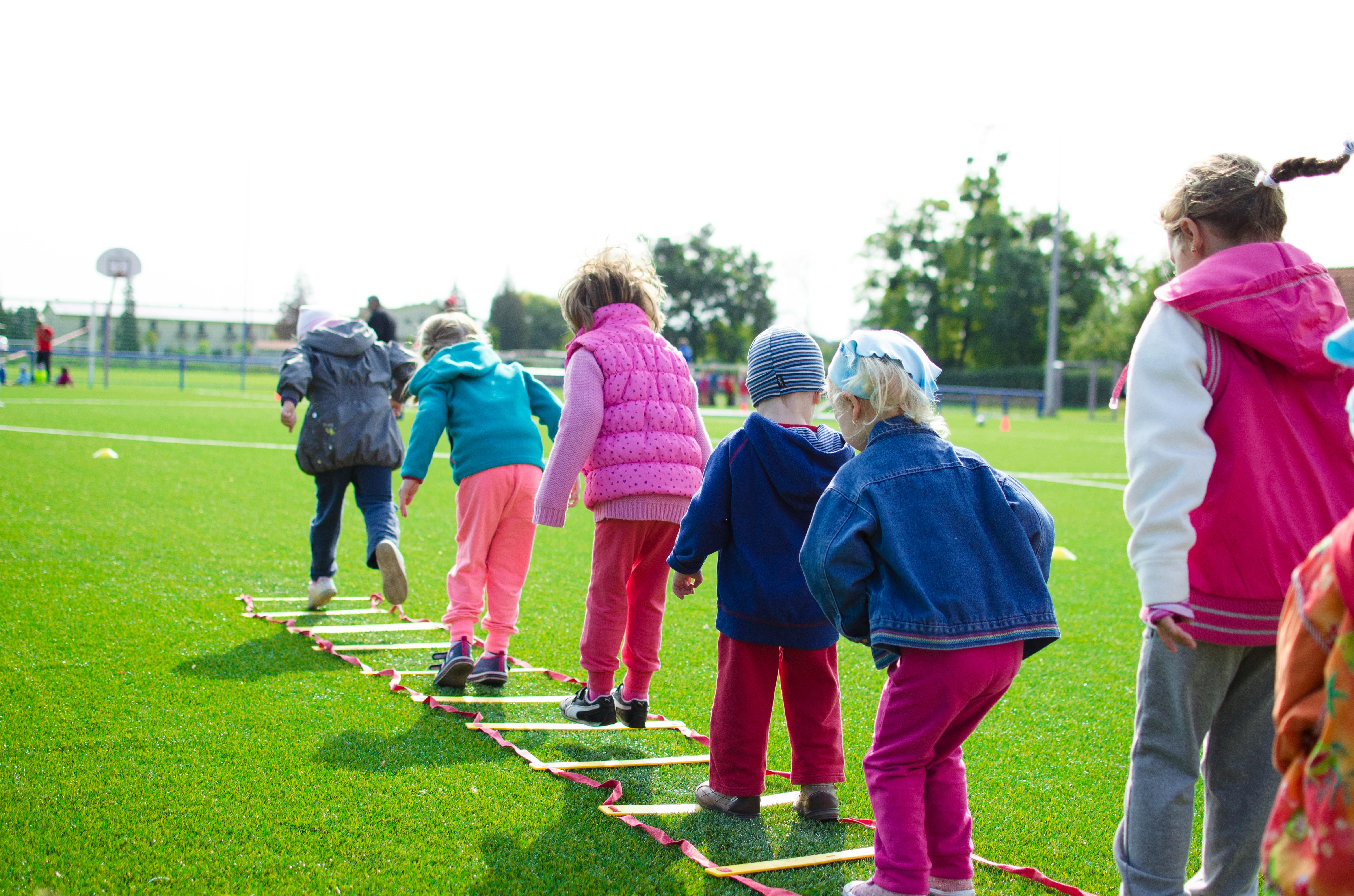 Children playing out on a field at school.