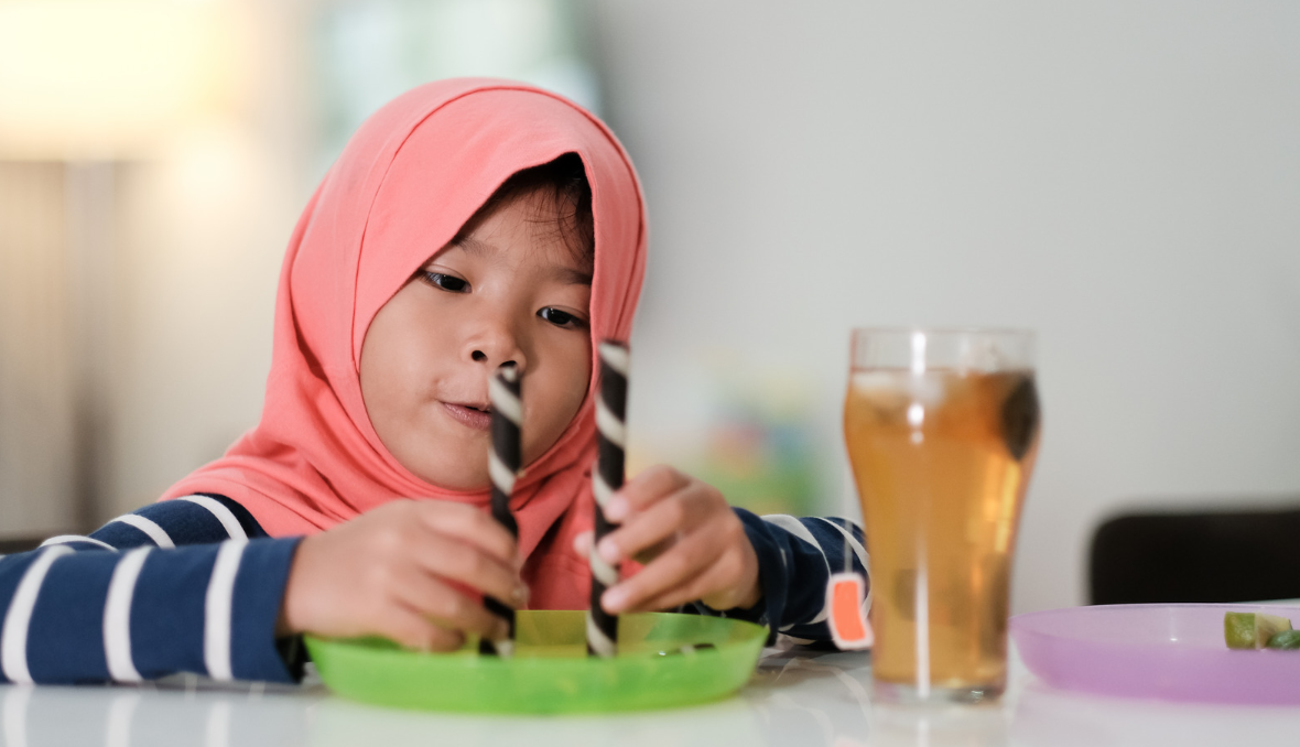 child measuring two wafer tubes on a table 