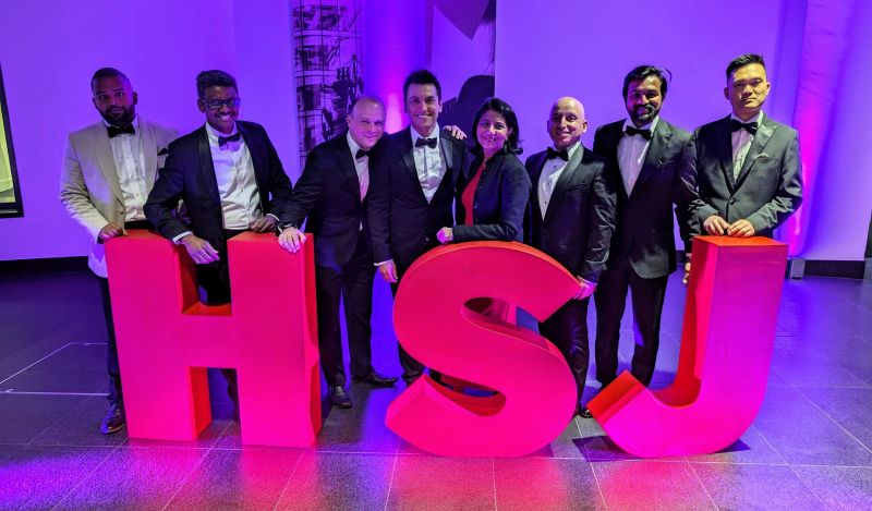 Data & Analyics Team posing behind an HSJ sign.