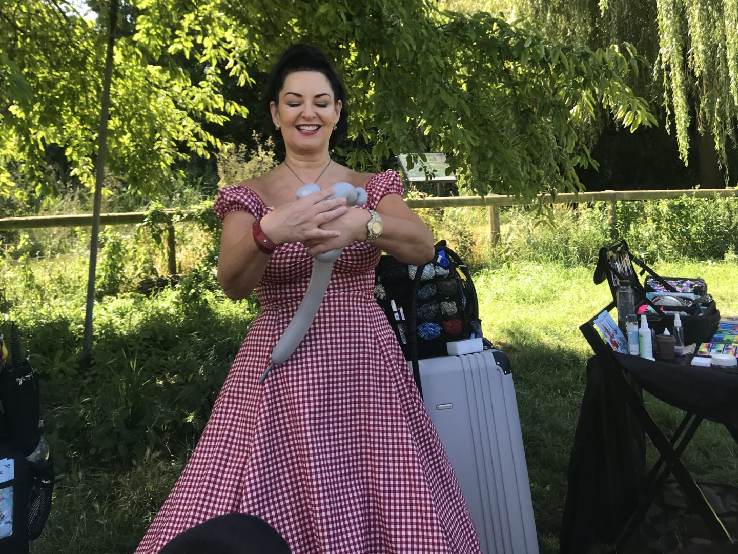 A staff member creating an animal balloon at the Summer Fete.