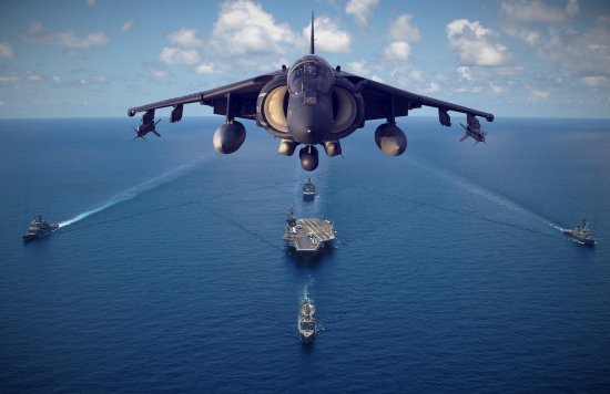 Jet in the air at sea above an aircraft carrier ship