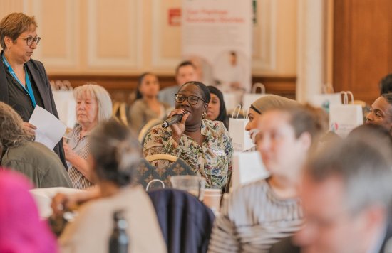 A guest asking a question during the conference