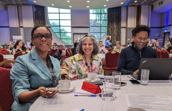 Three people at a table smiling