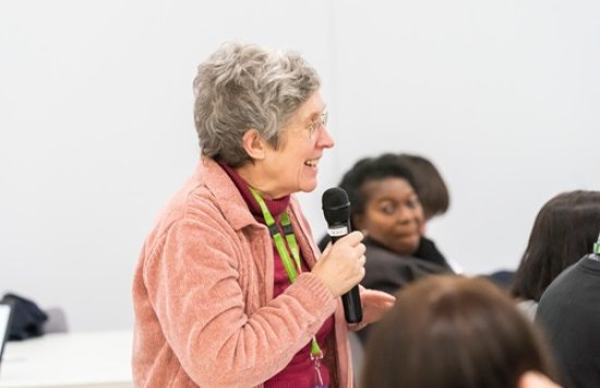 Photo of Shirley Biro holding a microphone.