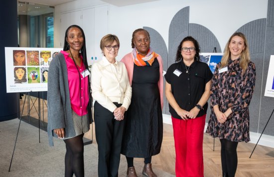 Lorraine Sunduza (3L) standing next to colleagues from Hestia, with pieces of art in the background.