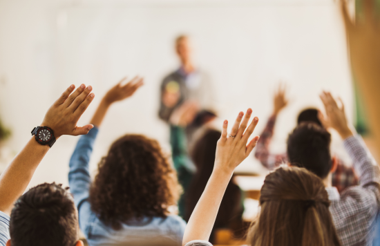 Stock image of people raising their hand.