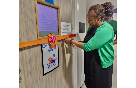 Lorraine Sunduza cutting a ribbon to open the low stimulus room