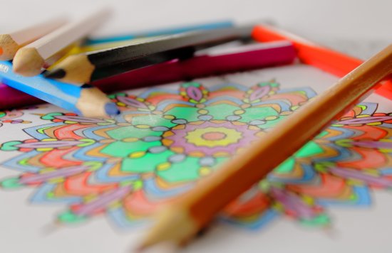 colouring book with pencils scattered on top