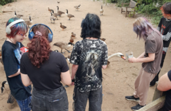 group of young people by pond with birds