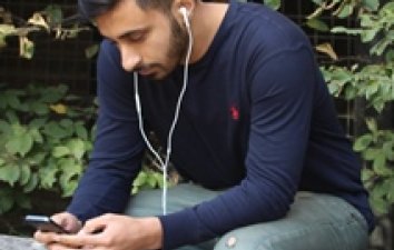 Man looking at phone with headphones in