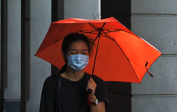 Lady in face mask with umbrella