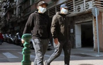 2 boys in face masks walking down street