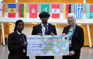 Two school pupils present cheque to ELFT manager
