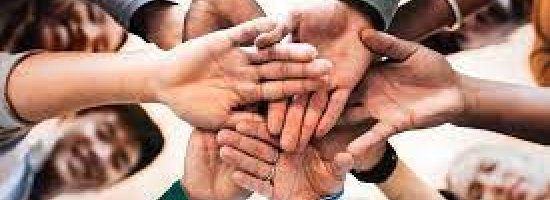 Group of people stacking hands in the middle of the group