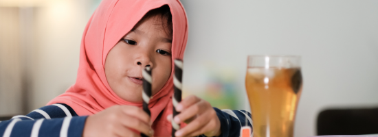 child measuring two wafer tubes on a table 